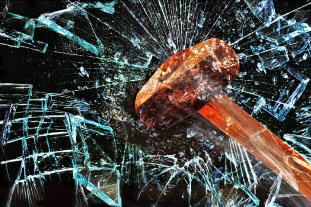 A hammer breaking a panel of glass representing chaos data engineering breaking data systems